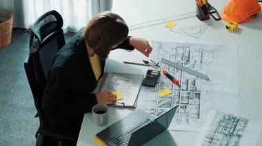 Zeki iş kadınlarının yürüyüşü ve ev tasarımı. Mimar mühendisinin güvenlik miğferi ve ev modeliyle birlikte binanın planına ve yapısına baktığı hava görüntüsü. Hizalama.