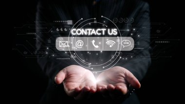 Profesyonel bir işadamı ellerini açık tutarak, iletişim yöntemleri için parlayan dijital simgeler sergiliyor, modern temas araçları ve teknolojiyi vurguluyor. Dörtgen