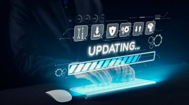 Parlak bir klavyeye, güncellenen bir ilerleme çubuğu ve yazılım bakımını temsil eden çeşitli teknoloji simgelerini gösteren dijital bir arayüzle yazı yazan bir kişi. Dörtgen