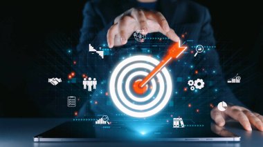 Hedef ve dijital unsurların yer aldığı bir iş stratejisinin modern bir temsili. Bu resim hedeflere, yenilikçiliğe ve analitik anlayışa ulaşma arayışını sembolize eder. Dörtgen