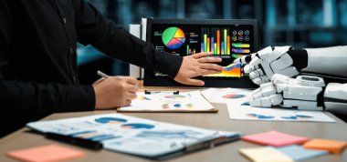 Robot ve insan arasındaki işbirliğini gösteren bir sahne. Grafikler ve grafiklerle ekrandaki verileri analiz ederek modern bir çalışma alanındaki yeniliği yansıtıyor. Noogenesis