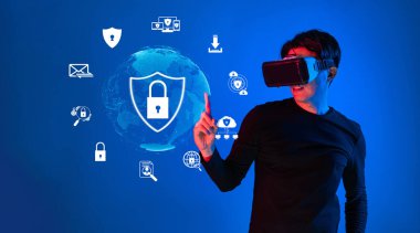 Sanal güvenlik ve veri korumasını temsil eden sanal simgelerle etkileşime giren VR kulaklık takan genç bir adam, dijital çağda güvenliğin önemini vurguluyor. XDMCP