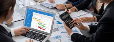 İş zekası ve veri analizi kavramı. Analizci ekibi laptop ekranında finansal veri analizi üzerinde çalışıyor. Etkili iş stratejik planlama için pazarlama göstergesi olarak. İçgörü