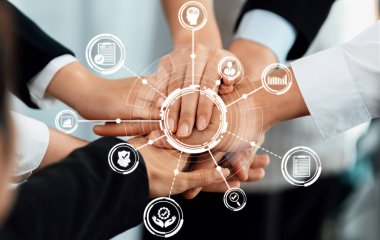 İş ortamında takım çalışması ve işbirliğinin güçlü bir temsili, birlik ve ilerlemeyi sembolize eden dijital simgelerle el ele veriliyor. Dostluk