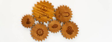 Bu resim, iş ve müşteri ilişkileri yönetiminde verimli süreçlerin önemini, bütünleşmeyi ve işbirliğini sembolize eden birbirine bağlı ahşap dişlileri içerir. Dostluk