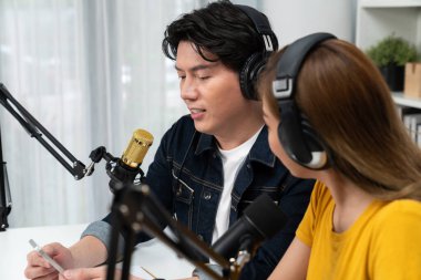 Gülümseyen radyo etkili sunucular, kulaklık takarak sosyal medya kanalından canlı yayın yapıyorlar ve sabah saatlerinde stüdyo kaydında dinleyicilere konu ve dizüstü bilgisayar üzerinden konuşuyorlar. İnfobahn.