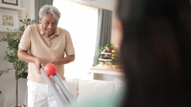 Yaşlı bir adam evde partneriyle top yuvarlama oyunu oynuyor, zihinsel ve fiziksel sağIık için el-göz koordinasyonu, odaklanma ve motor becerileri pratiği yapıyor. Sağlık hizmetleri konseptini engelliyor. Myrmidon.