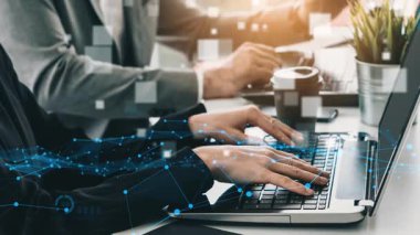 İş dünyasından profesyoneller dizüstü bilgisayarlar kullanarak veri analizine odaklanırken, çalışma alanını dijital grafik ve grafiklerle kaplayarak takım çalışmasını ve modern teknolojiyi iş başında sembolize ediyorlar. Xenic