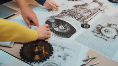 Mühendisler, modern bir çalışma alanında teknik çizimler ve çeşitli parçaları içeren mekanik tasarım planları üzerinde aktif olarak işbirliği içinde çalışırlar, takım çalışması ve yenilik sergilerler. SACTR