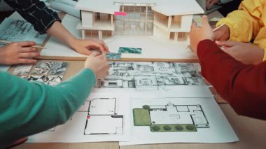 Mimari modeller ve tasarım planları üzerinde çalışan, proje planlama ve geliştirmede işbirliği ve yaratıcılık sergileyen ellerle dolu dinamik bir çalışma alanı. SACTR