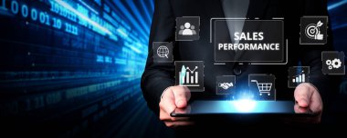 Bir iş adamı dijital pazarlama verileri ve analitik grafikleri kullanarak modern, yüksek teknoloji ortamında online satış performansını analiz eder. XDMCP