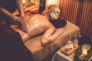 Beyaz kadın müşteri stres önleyici spa masajının keyfini çıkarıyor ve lüks otel ya da otelde sıcak mum ışığında güzellik teniyle eğleniyor. Sessiz.