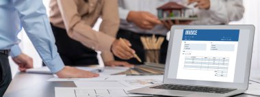 İç mimar tasarımcı grubu, daha kesin tasarım için planlar ve dizüstü bilgisayar ekran mimari yazılımı üzerinde birlikte tartışıyorlar. Modern ev tasarımı ve yenileme. İçgörü