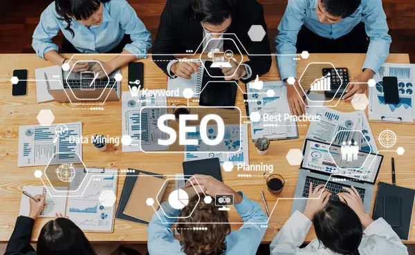 Veri ve SEO stratejileri üzerinde işbirliği yapan bir grup profesyonelde, takım çalışması ve iş büyümesini vurgulayan çeşitli belgeler ve analiz araçları yer alıyor. Dostluk