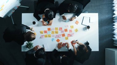 Profesyonel iş adamlarının yapışkan notlarla pazarlama fikirlerini yazıp paylaştıkları en tepeden aşağı hava görüşü. Çeşitli yönetici yöneticilerin birlikte çalışması ya da beyin fırtınası stratejisi. Müdürlük.