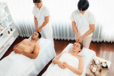 Kafkasyalı çift stres önleyici kafa masajının keyfini çıkarıyor ve lüks otellerde ya da otel spa salonlarında gündüz kaplıcalarında yüz güzelliği eğlencelerini şımartıyor. Sessiz.