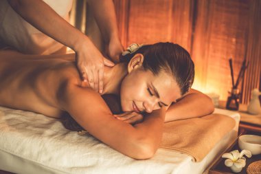 Beyaz kadın müşteri stres önleyici spa masajının keyfini çıkarıyor ve lüks otel ya da otelde sıcak mum ışığında güzellik teniyle eğleniyor. Sessiz.