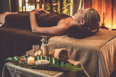 Aromaterapi masajı ambiyansı ya da spa salonu kompozisyon düzeneği bulanık kadınlara odaklı dekor mumları ve spa aksesuarları ile tatil köyü veya otel arka planında keyifli aroma spa masajı yapan. Sessiz.
