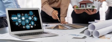 İç mimar tasarımcı grubu, daha kesin tasarım için planlar ve dizüstü bilgisayar ekran mimari yazılımı üzerinde birlikte tartışıyorlar. Modern ev tasarımı ve yenileme. İçgörü