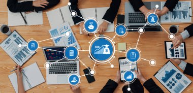 Dinamik bir ofis toplantısı, iş vergisi sunumunda dizüstü bilgisayarlar, tabletler ve not defterlerindeki veriler, takım çalışması ve işbirliğini vurguluyor. Dostluk