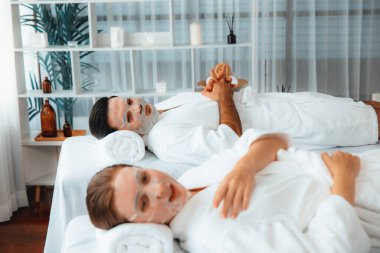 Kaplıca salonunun sakin, modern gündüz atmosferi, birkaç müşteri yüz maskesi takarak kendini yenilemeye çalışıyor. Yüz bakımı ve güzellik kozmetolojisi prosedürü. Sessiz.