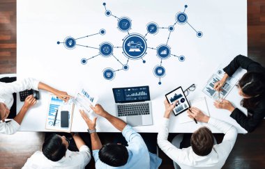 Çeşitli bir iş ekibi, modern bir çalışma alanı ortamında bilgilendirilmiş kararlar almak için teknoloji ve görsel yardımlardan yararlanan bir veri analiz oturumunda yer alıyor. Dostluk