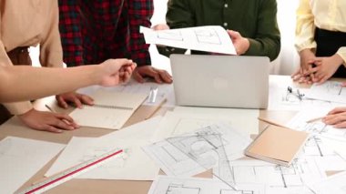 Akıllı mimar ve güvenlik mühendisi, mimari belge, ölçüm araçları ve ahşap blokların modern ofiste etrafa saçıldığı masa planlarını tartışıyor. - Yakın çekim. Tanımlama.