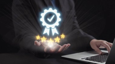 Bir iş adamı, dijital bir ödülü parlayan yıldızlarla birlikte dizüstü bilgisayar kullanarak, rekabetçi bir pazarda tanınma ve başarının önemini vurgulayarak sergiliyor. Dörtgen