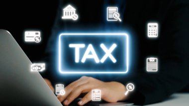 Vergilerle ilgili çeşitli simgelerle çevrili bir dizüstü bilgisayar kullanan, modern mali yönetimi, bütçeyi ve dijital kayıt tutmanın önemini temsil eden bir kişi. Dörtgen