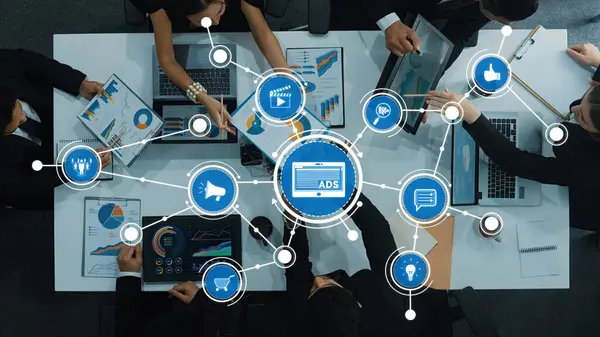 Reklam verilerini analiz eden ve modern bir ofis alanında dijital ekranlar aracılığıyla yenilikçi stratejiler sunan profesyonellerle dinamik bir iş toplantısı. Dostluk