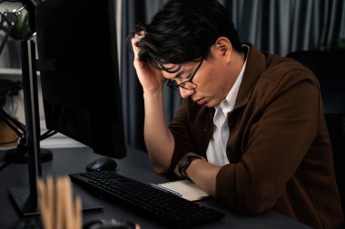 Stresli yüzü olan zeki bir işadamı, gece geç saatlerde ofiste yüksek satış gelirleri olan müşteriden e-posta bekliyor. Şirket projesinde çalışıyor. İnfobahn.