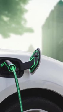 Yeşil Şehir Parkı 'ndaki ekolojik temiz enerji şarj istasyonundan gelen fütürist akıllı EV şarj aletinin şarj ettiği elektrikli araba. Alternatif enerji kullanan gelecekçi elektrikli araba. İnceleyin