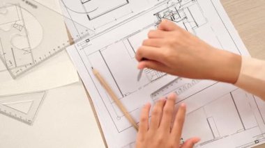 Akıllı mimar ya da akıllı mühendisin ölçüm aracı ve mimari ofisindeki inşaat doğruluğu için plan üzerinde bölücü el yazısı detaylarını kullanmasının videosu. Eline odaklan. - Yakın çekim. Tanımlama.