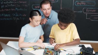 Zeki akıl hocası ana tahtanın yapımını öğretirken farklı gençlerin öğrenme sistemleri var. Öğretmen, akademik öğrenci elektronik ekipman kullanmayı öğrenirken anakart yapısını açıklıyor. Öğretim