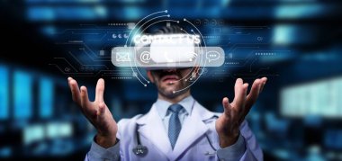 Sanal gerçeklik kulaklığı takan bir sağlık uzmanı modern bir tıbbi ortamda dijital elementlerle etkileşime giriyor ve gelecekteki sağlık teknolojisi ve yenilikleri gözler önüne seriyor. PHMT