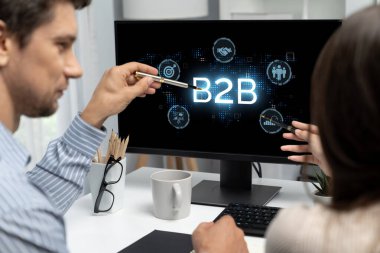 İş adamı B2B peyzajında geziniyor, iş-iş bağlantılarını geliştirmek için kullanım teknolojisi kullanıyor. B2B etkileşimini yeniden şekillendiren keşifler, iş-iş stratejilerinde yenilikleri yönlendiren araçlar. canlı