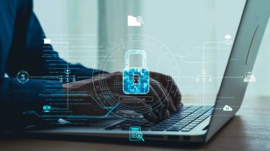 Modern bir çalışma alanında siber güvenlik ve veri koruması temalarını vurgulayan bir dizüstü bilgisayarda el yazması dijital güvenlik sembolleri sergileniyor. Dörtgen