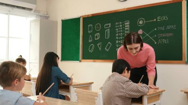 Zeki öğretmen sınıfta fikri açıklarken sevimli öğrenci ödevlerini kontrol ediyor. Not defterine bakıp matematik teorisinden çocuğa bahsederken sınıfta dolaşan çekici bir eğitmen. Pedagoji.