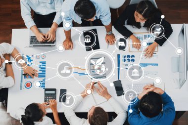 Çeşitli profesyonellerin verileri analiz ettiği ve modern ofis ortamında büyüme stratejilerini tartıştığı, takım çalışması ve teknolojinin yer aldığı dinamik bir iş toplantısı. Dostluk