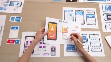 Mobil uygulama için kullanıcı arayüzü prototipi ya da masadaki program modeliyle birlikte web sitesi planlaması yapan bir şirket çalışanı. UX UI tasarımcısı kullanıcı dostu arayüz planını dikkate alır. Sinerjik