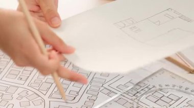 Mimari döküman, ölçüm araçları ve ahşap blokların modern ofiste etrafa saçıldığı masa üzerine planlar yapma konusunda akıllı mimar ve güvenlik mühendisi tartışması. - Yakın çekim. Tanımlama.