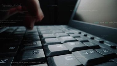 Yazılım geliştirme ve teknolojinin karmaşıklığını gösteren programlama kodları ve dijital semboller içeren bir klavyeye el yazısı yazan yakın plan bir resim. Xenic