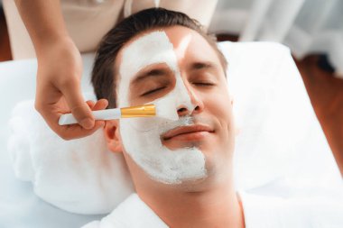 Kaplıca salonunun sakin atmosferi, insan müşterisi modern gün ışığında lüks yüz kremi masajıyla kendini yenileme zevkine kapılıyor. Yüz bakımı ve güzellik konsepti. Sessiz.