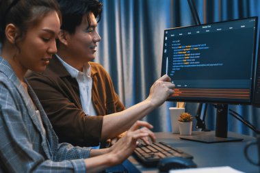 Bilgi teknolojisi geliştiricileri modern ofisteki neon ışık odasında verileri çevrimiçi olarak çalıştıran akıllı web sitesi geliştirme kodlayıcı sistemine işaret ediyorlar. İnfobahn.