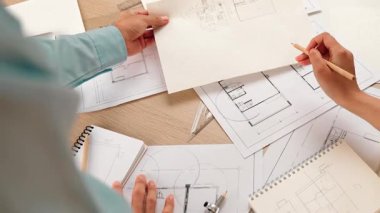 Mimari ekipmanlarla toplantı masasında ev tasarımı üzerine profesyonel mühendis ekibi tartışması ve modern ofiste bina planı dağılımı. Eline odaklan. - Yakın çekim. Tanımlama.