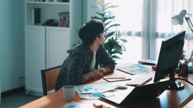 İç mimar dizüstü bilgisayarı, bilgisayarı ve kâğıdı olan toplantı masasında palete bakarken dizüstü bilgisayara bakıyor ve renk tasarlıyor. Renk tasarımı üzerinde çalışan iş adamına yakın çekim. Sempozyum.