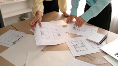 Mimarlık ve güvenlik mühendisi, modern ofiste dizüstü bilgisayarda mimari belge ve ahşap blokla sergilenen planlar hakkında tartıştı. - Yakın çekim. Tanımlama.