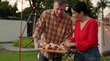 Aile hep birlikte bahçede kamp kurar, yaşlı bir çift barbekü yapar, yemek yer. Son sınıflar kamp faaliyetlerini kullanırlar, doğayla iç içe olurlar ve genç nesil çapraz kuşaklarla zaman geçirirler. Uyumsuzluk.