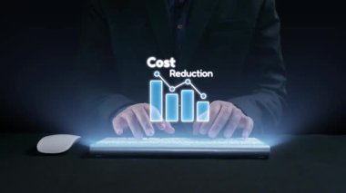 Bir iş adamı dijital grafikler ve simgeler gösteren modern bir klavye kullanıyor. Bu sahnede şirket dünyasında maliyet düşüşü ve stratejik mali yönetim vurgulanıyor. Dörtgen