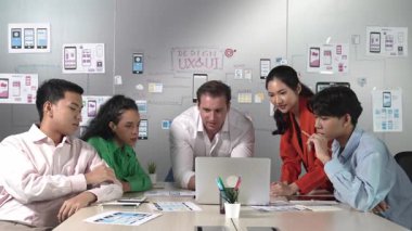 Profesyonel başarılı iş ekibi dizüstü bilgisayar kullanarak birlikte çalışıyor. Bir grup iş adamı projeyi tartışırken Asyalı genç iş kadını dizüstü bilgisayar getiriyor. Yönlendirici.